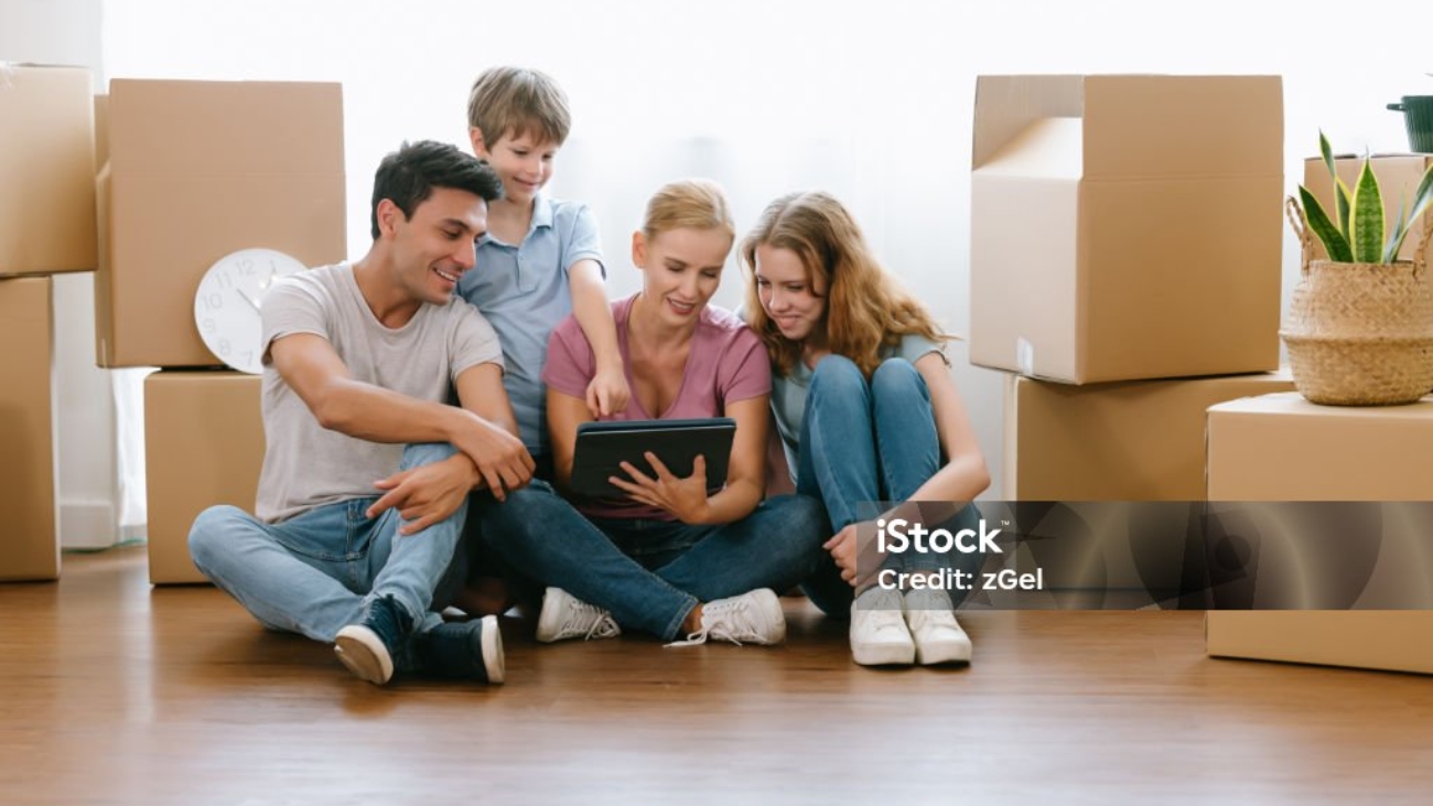 Caucasian Family father mother daughter son sit on the floor using digital tablet shopping online choosing and ordering Furniture, Discussing Decor at home. Lifestyle happy family together relocation